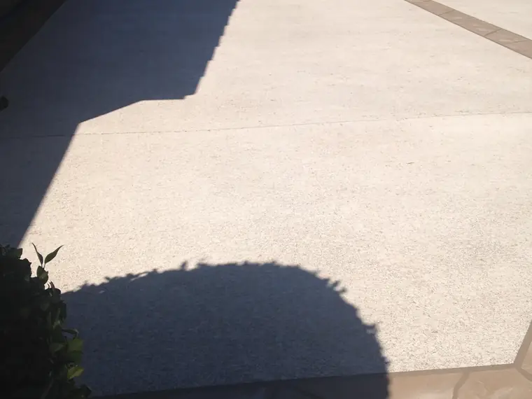 Cream resurfaced patio with a contrasting border in low sunlight