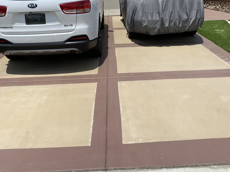 Resurfaced driveway in cream with brown banding and parked cars