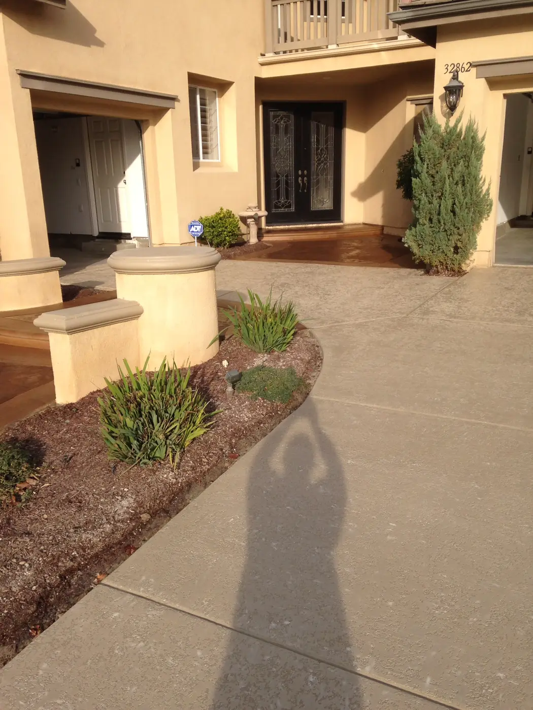 Resurfaced tan entry walkway leading to a residential front door