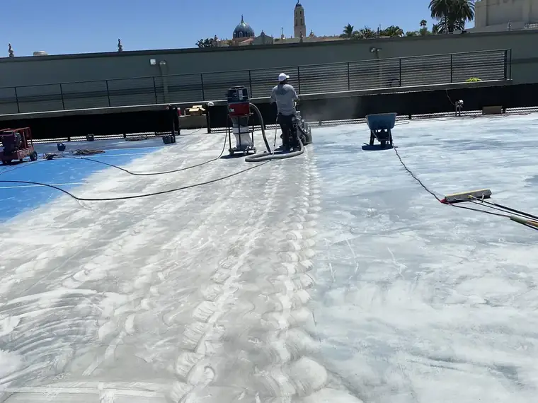 Court part-stripped, with grinding dust across the exposed concrete