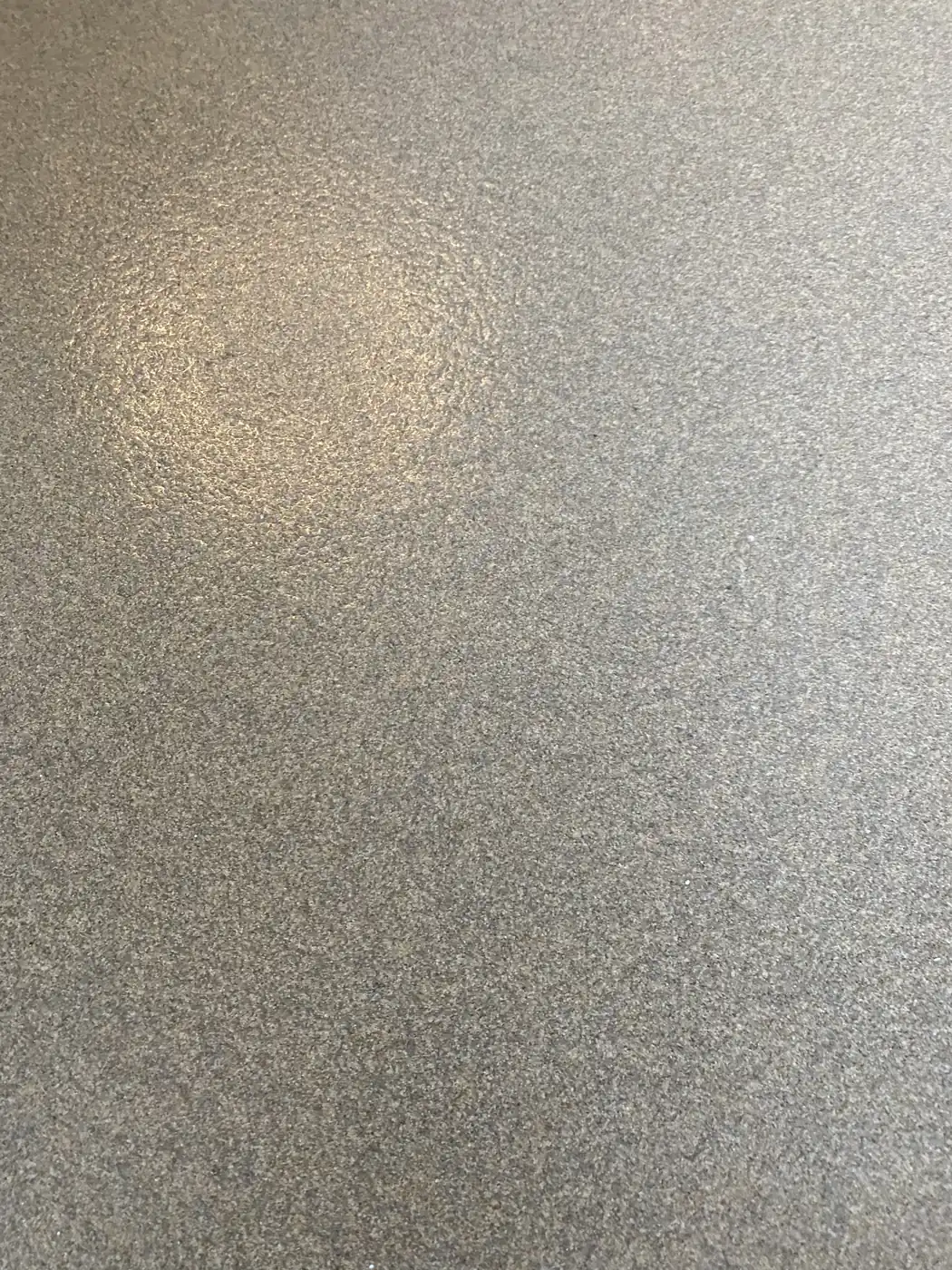 Close view of gray and black flake broadcast into a clear epoxy topcoat