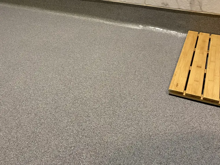 Gray flake epoxy floor beside a stacked timber pallet