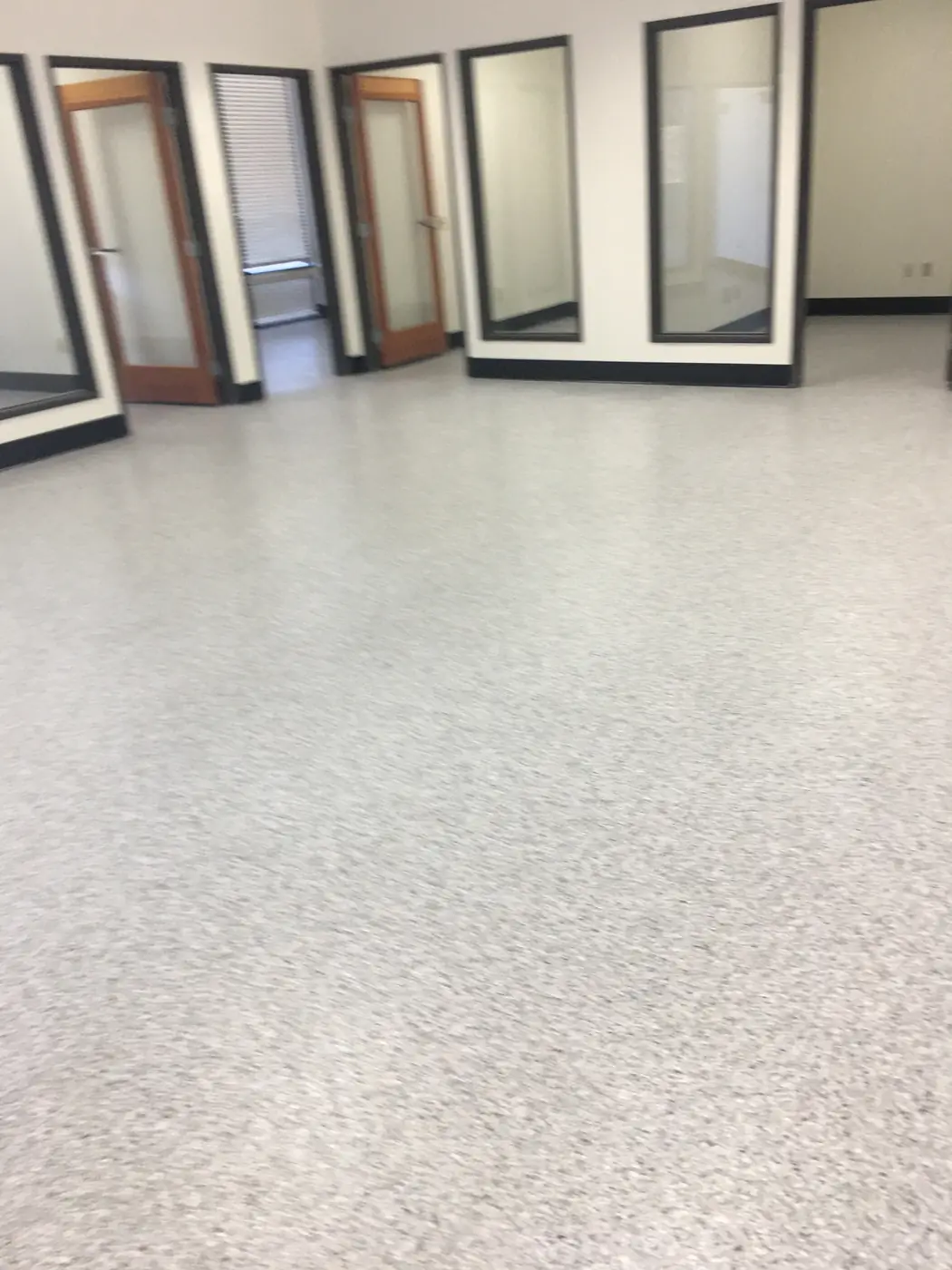 Light gray flake epoxy floor in a showroom stacked with window frames