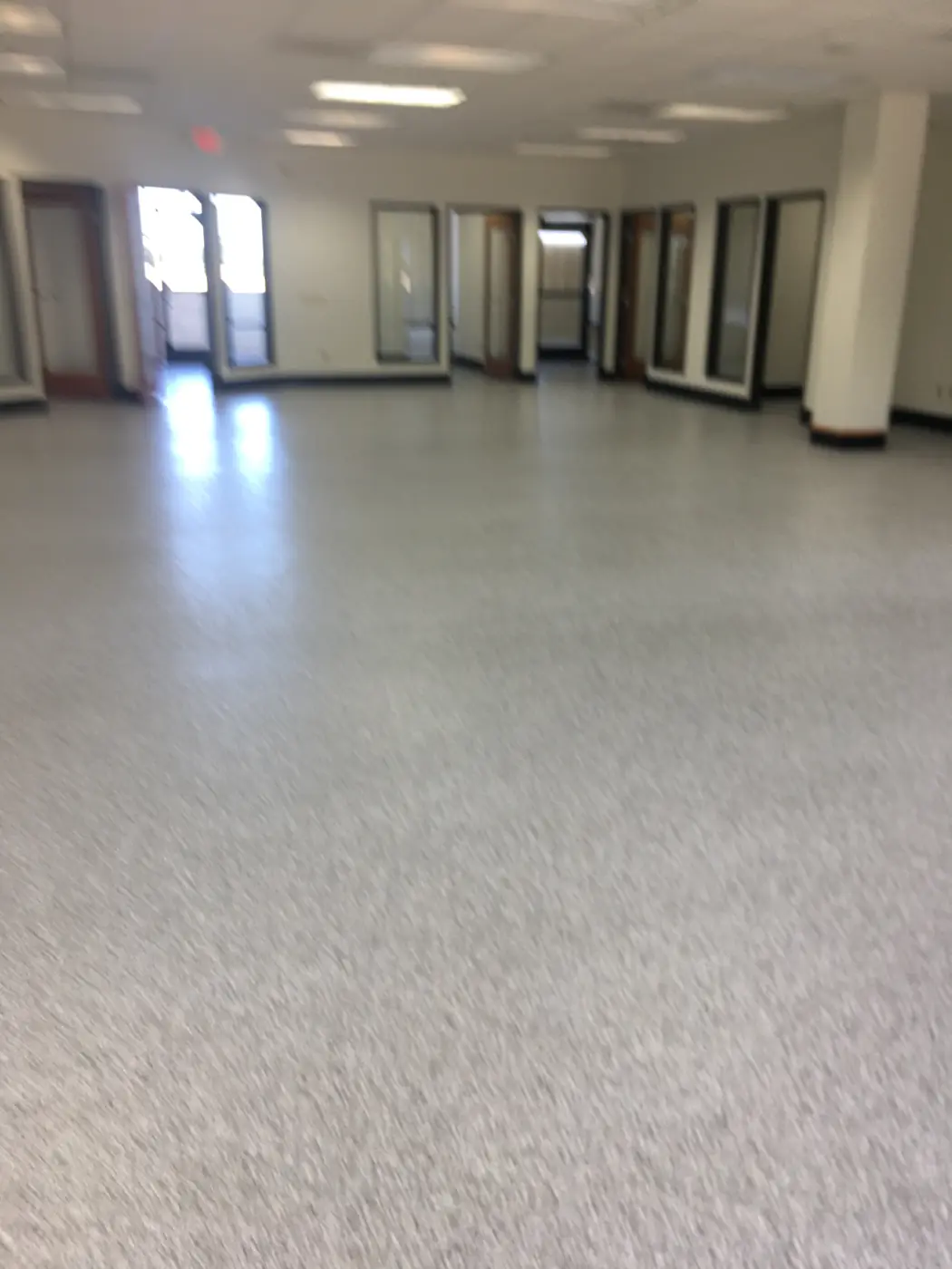 Light gray flake epoxy floor running through an empty open office