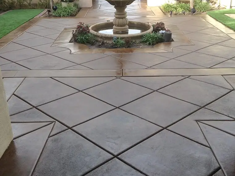 Diamond-scored stained courtyard leading to a tiled fountain