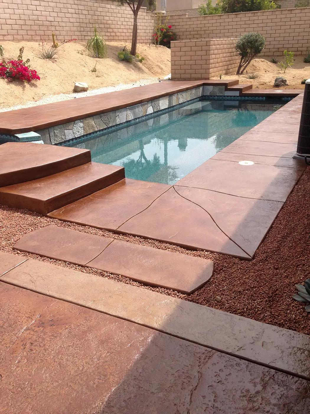 Red stained pool deck and steps set in a red rock landscape