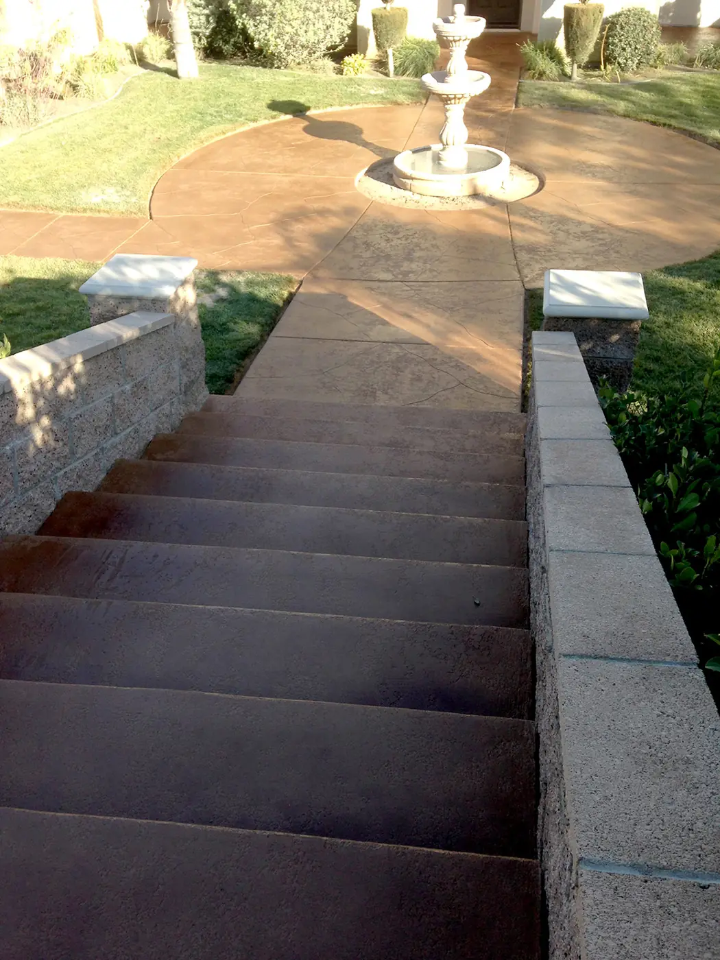Stained steps leading down to a courtyard fountain