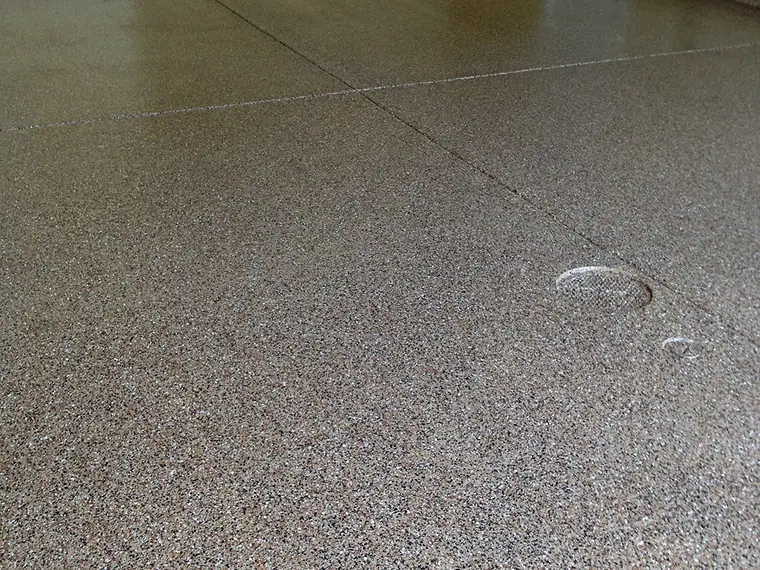 Gray flake epoxy garage floor with a coved edge along the wall
