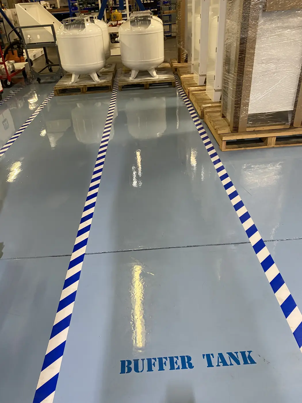 Pale blue epoxy plant floor with blue and white striped walkway lines and a stencilled label