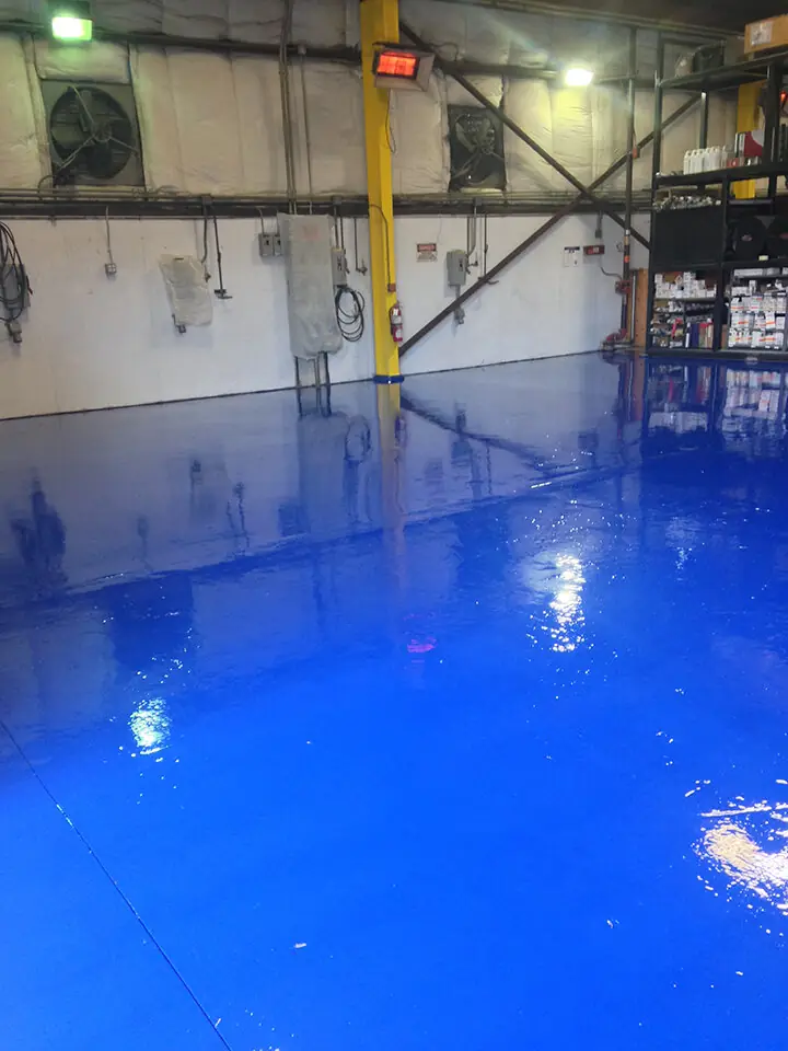 Wet-look blue epoxy floor in an industrial workshop