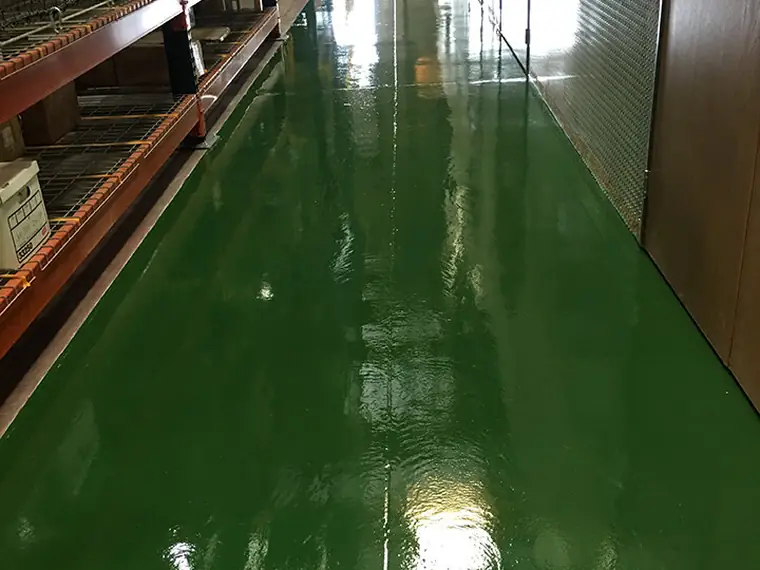 Green epoxy aisle running between tall warehouse racking