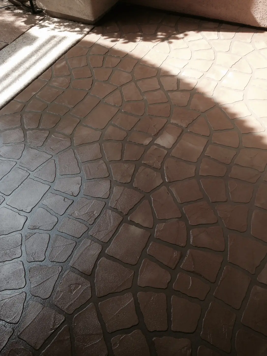 Brown stamped concrete overlay in a rounded cobblestone pattern