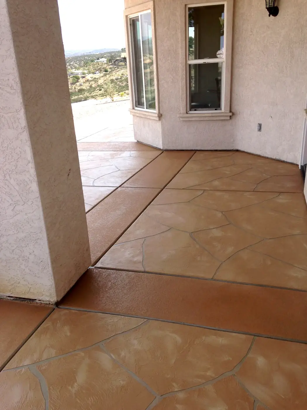 Terracotta stamped overlay patio running along the side of a house