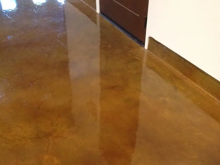 Amber stained concrete hallway floor reflecting the doorways
