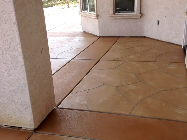 Terracotta stained floor scored in a tile pattern beside a window
