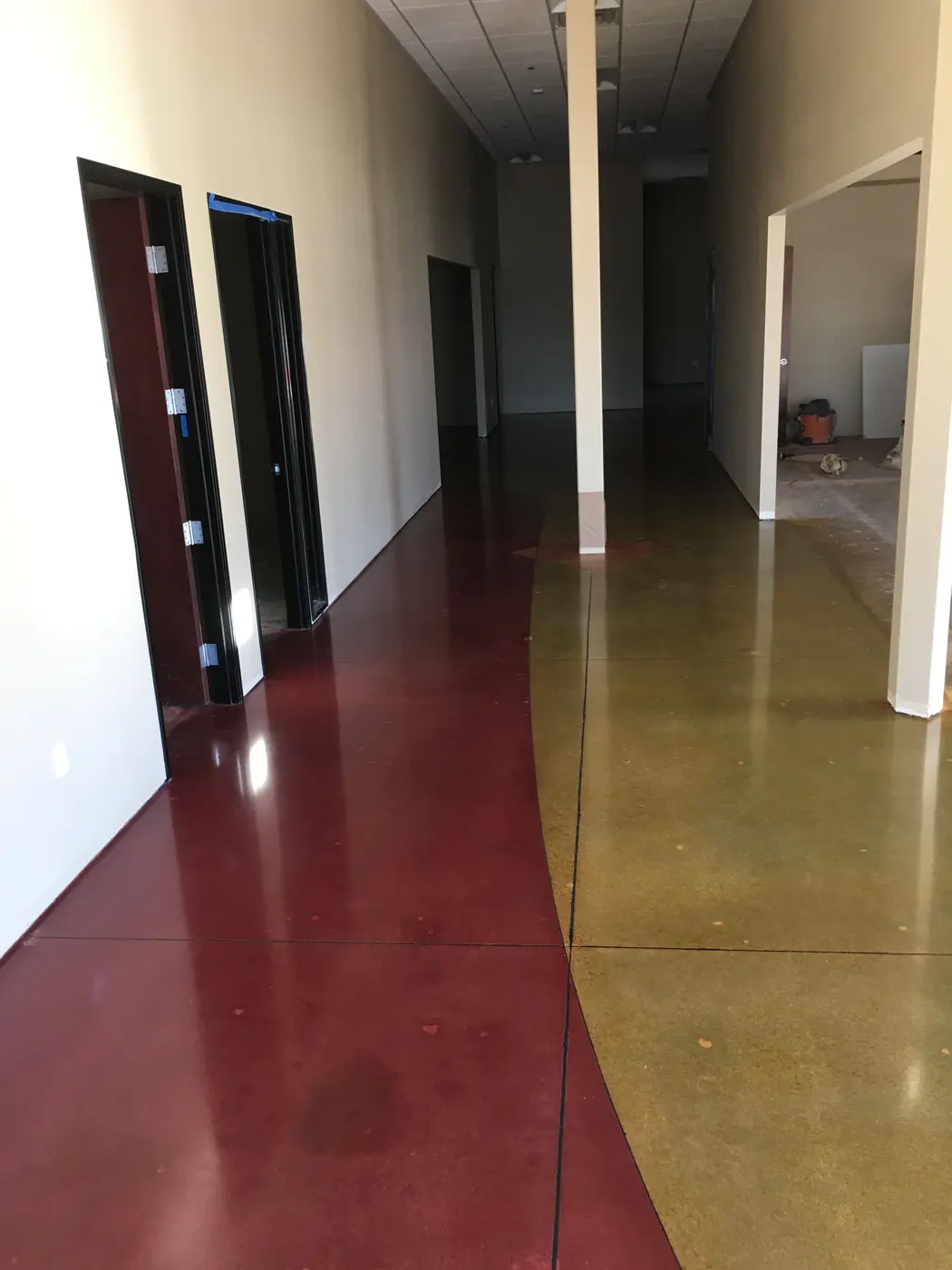 Polished stained floor in olive and deep red running down a corridor