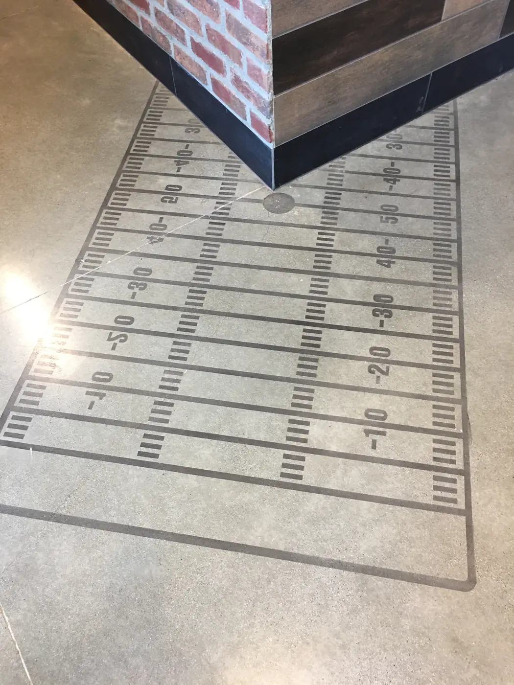 Football field graphic with yard markings cut into a polished concrete floor