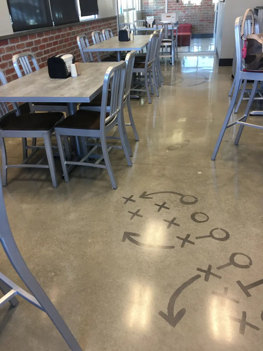Polished floor with an X and O play diagram in a cafeteria seating bay