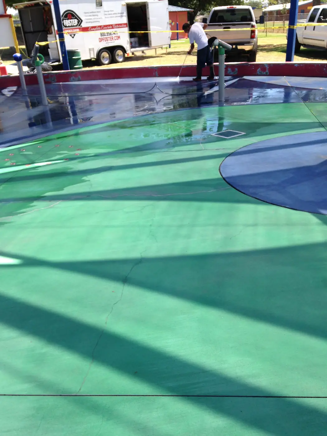 Green, blue and red splash pad coating under a play structure