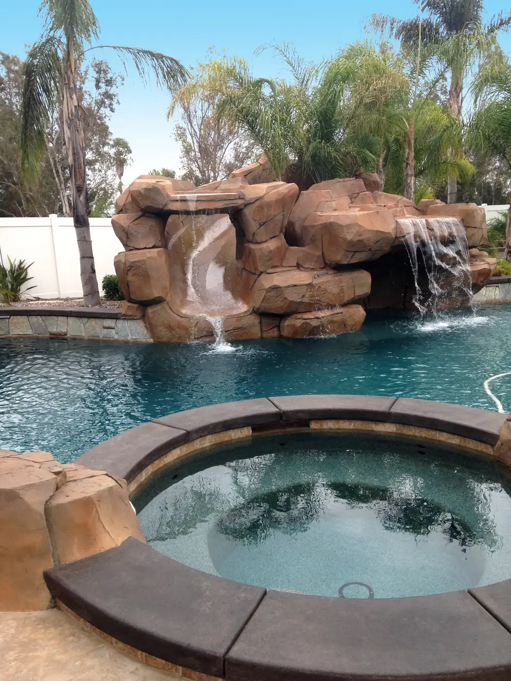 Restained rock grotto above a pool and spa