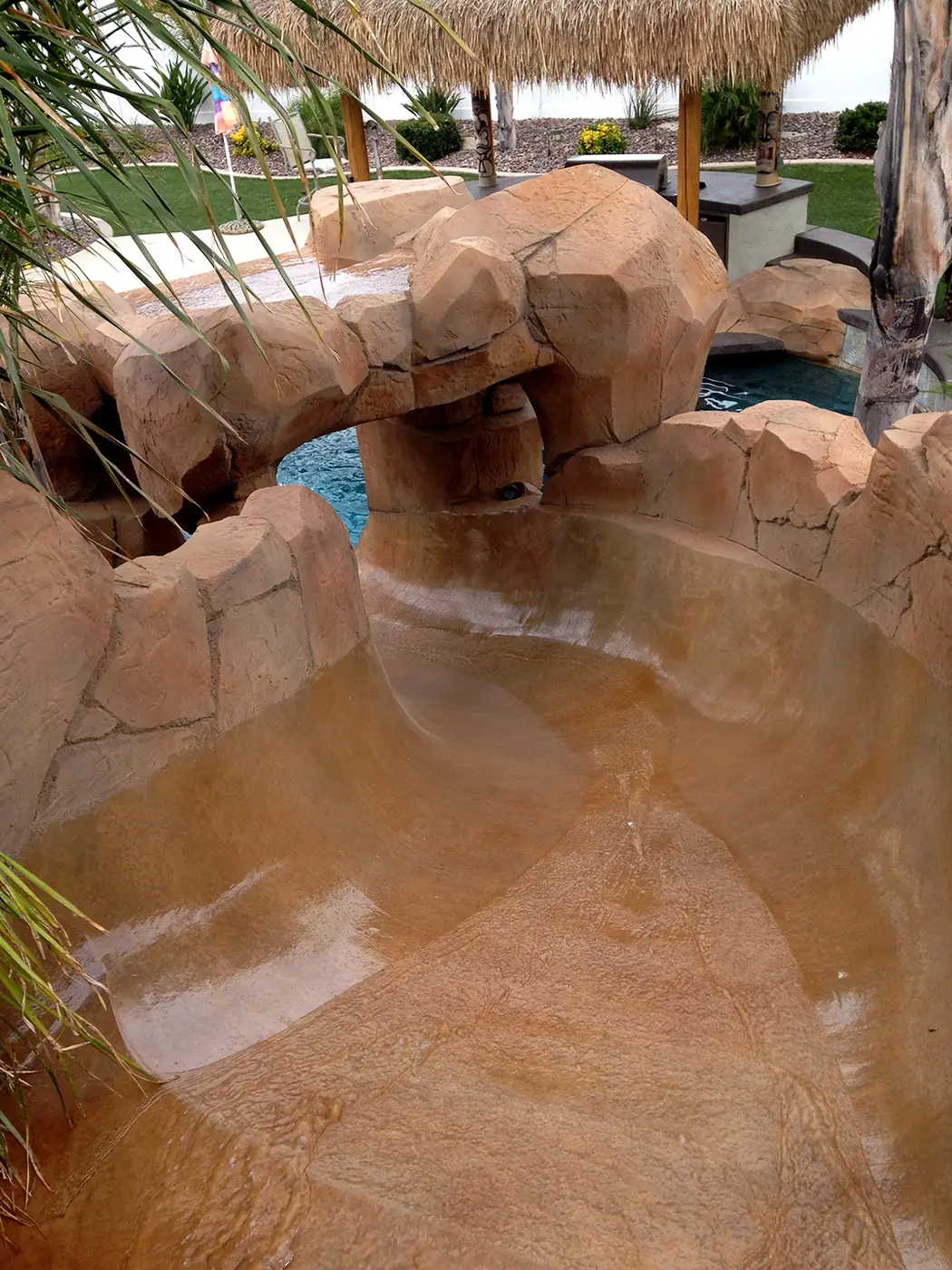 Restained faux rock waterslide running into a pool
